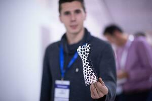 young engineer showing 3D printed model photo