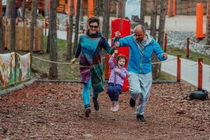 Family fun in the park. Happy family spending time in park and playing with their daughter photo