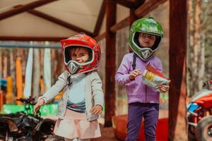 dos pequeño muchachas teniendo divertido en el parque mientras vistiendo un motocicleta casco en su cabezas foto