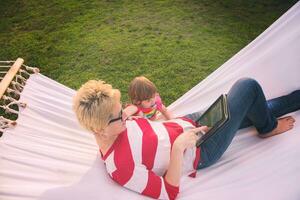 mom and a little daughter relaxing in a hammock photo