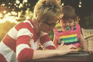 mom and her little daughter using tablet computer photo