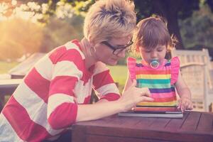 mom and her little daughter using tablet computer photo