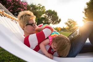 mamá y una pequeña hija relajándose en una hamaca foto