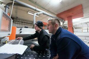 carpenters calculating and programming a cnc wood working machine photo