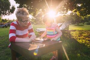 mom and her little daughter using tablet computer photo