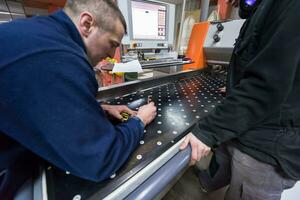 carpenters calculating and programming a cnc wood working machine photo