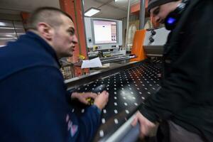 carpenters calculating and programming a cnc wood working machine photo