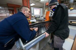 carpenters calculating and programming a cnc wood working machine photo