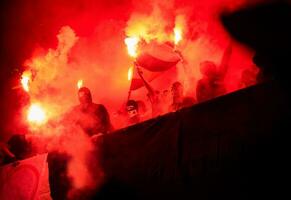 vándalos de fútbol con máscara sosteniendo antorchas en llamas foto