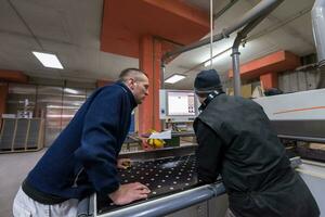 carpenters calculating and programming a cnc wood working machine photo