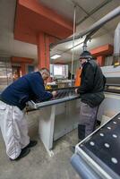 carpenters calculating and programming a cnc wood working machine photo