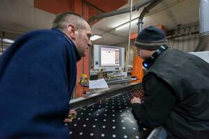 carpenters calculating and programming a cnc wood working machine photo