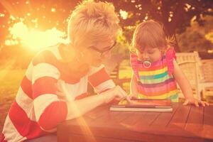 mom and her little daughter using tablet computer photo