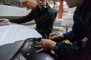 carpenters calculating and programming a cnc wood working machine photo