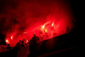 football hooligans with mask holding torches in fire photo