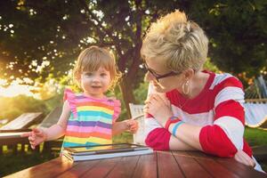 mom and her little daughter using tablet computer photo