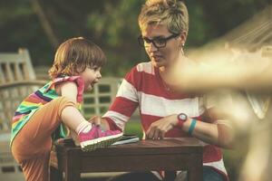 mom and her little daughter using tablet computer photo