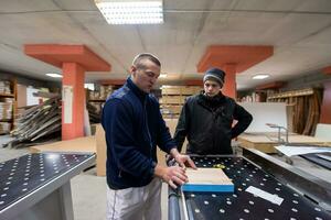 carpinteros calculando y programando una máquina de trabajo de madera cnc foto