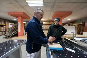 carpenters calculating and programming a cnc wood working machine photo