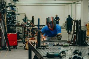 Professional Heavy Industry Welder Working Inside factory, Wears Helmet and Starts Welding. Selective Focus photo