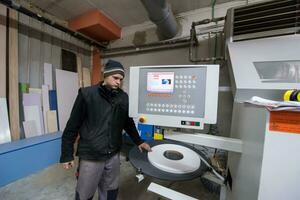 carpintero calculando y programando una máquina de trabajo de madera cnc foto