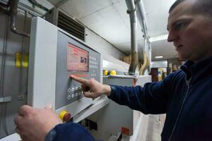 carpenter calculating and programming a cnc wood working machine photo