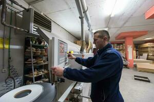 carpenter calculating and programming a cnc wood working machine photo