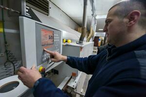 carpenter calculating and programming a cnc wood working machine photo