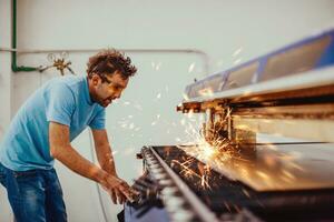 Within heavy industry. A man works in a modern factory on a CNC machine. Selective focus photo