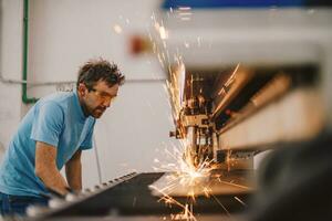 Within heavy industry. A man works in a modern factory on a CNC machine. Selective focus photo