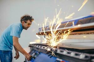 Within heavy industry. A man works in a modern factory on a CNC machine. Selective focus photo