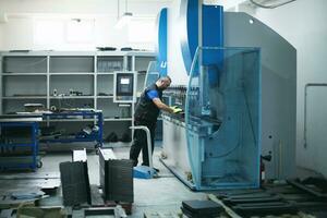 un trabajador o ingeniero de fábrica inteligente fabrica máquinas en un taller de producción. el concepto de industria e ingeniería. enfoque selectivo foto