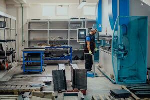 un trabajador o ingeniero de fábrica inteligente fabrica máquinas en un taller de producción. el concepto de industria e ingeniería. enfoque selectivo foto