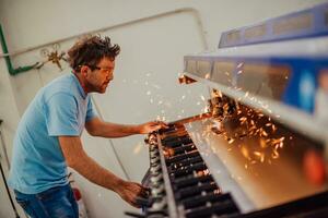 Within heavy industry. A man works in a modern factory on a CNC machine. Selective focus photo