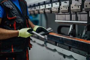 A smart factory worker or engineer makes machines in a production workshop. The concept of industry and engineering. Selective focus photo