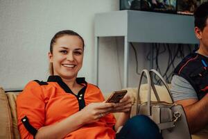 The woman sits on the sofa at her workplace and uses her smartphone during the break. Selective focus photo