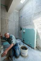 worker using level tool while installing big ceramic tiles photo