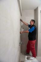 professional plumber working in a bathroom photo