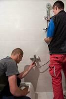 professional plumbers working in a bathroom photo
