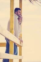 young couple drinking beer together at the beach photo