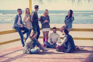 grupo de amigos divirtiéndose el día de otoño en la playa foto