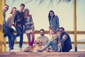 grupo de amigos divirtiéndose el día de otoño en la playa foto