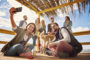 grupo de amigos divirtiéndose el día de otoño en la playa foto