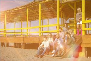 Group of friends having fun on autumn day at beach photo