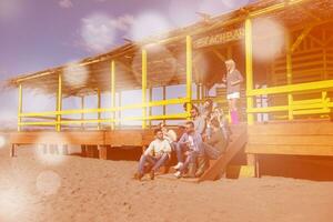 grupo de amigos divirtiéndose el día de otoño en la playa foto