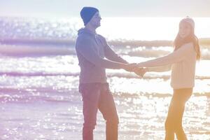 Loving young couple on a beach at autumn sunny day photo