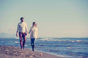 Loving young couple on a beach at autumn sunny day photo