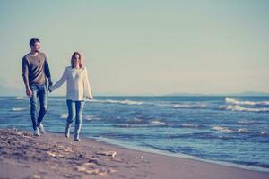 Loving young couple on a beach at autumn sunny day photo