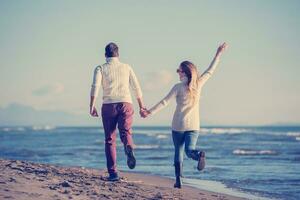 Loving young couple on a beach at autumn sunny day photo