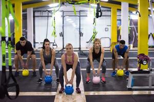 athletes doing exercises with kettlebells photo